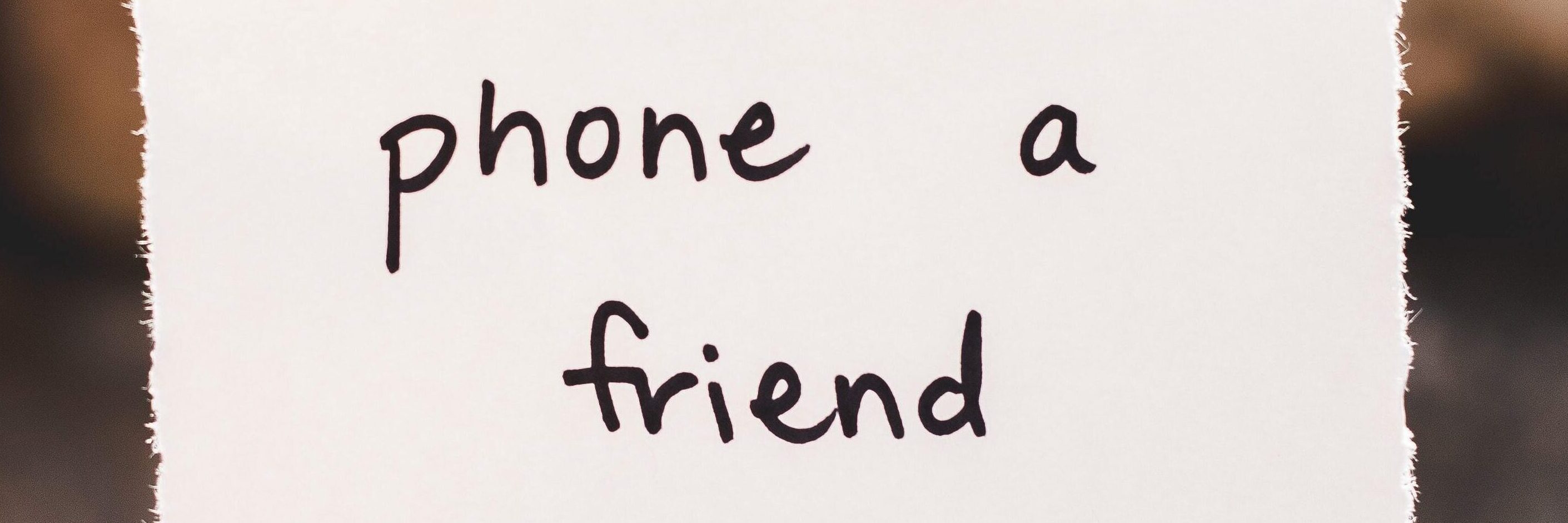 Person holding a note that says 'phone a friend'